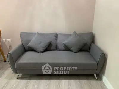 Modern gray sofa in a stylish living room with light wood flooring.