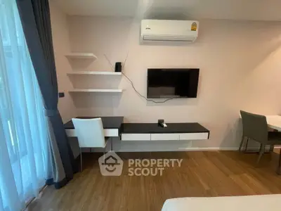 Modern study area with wall-mounted TV and air conditioning in stylish apartment.