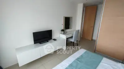 Modern bedroom with TV and vanity in sleek apartment