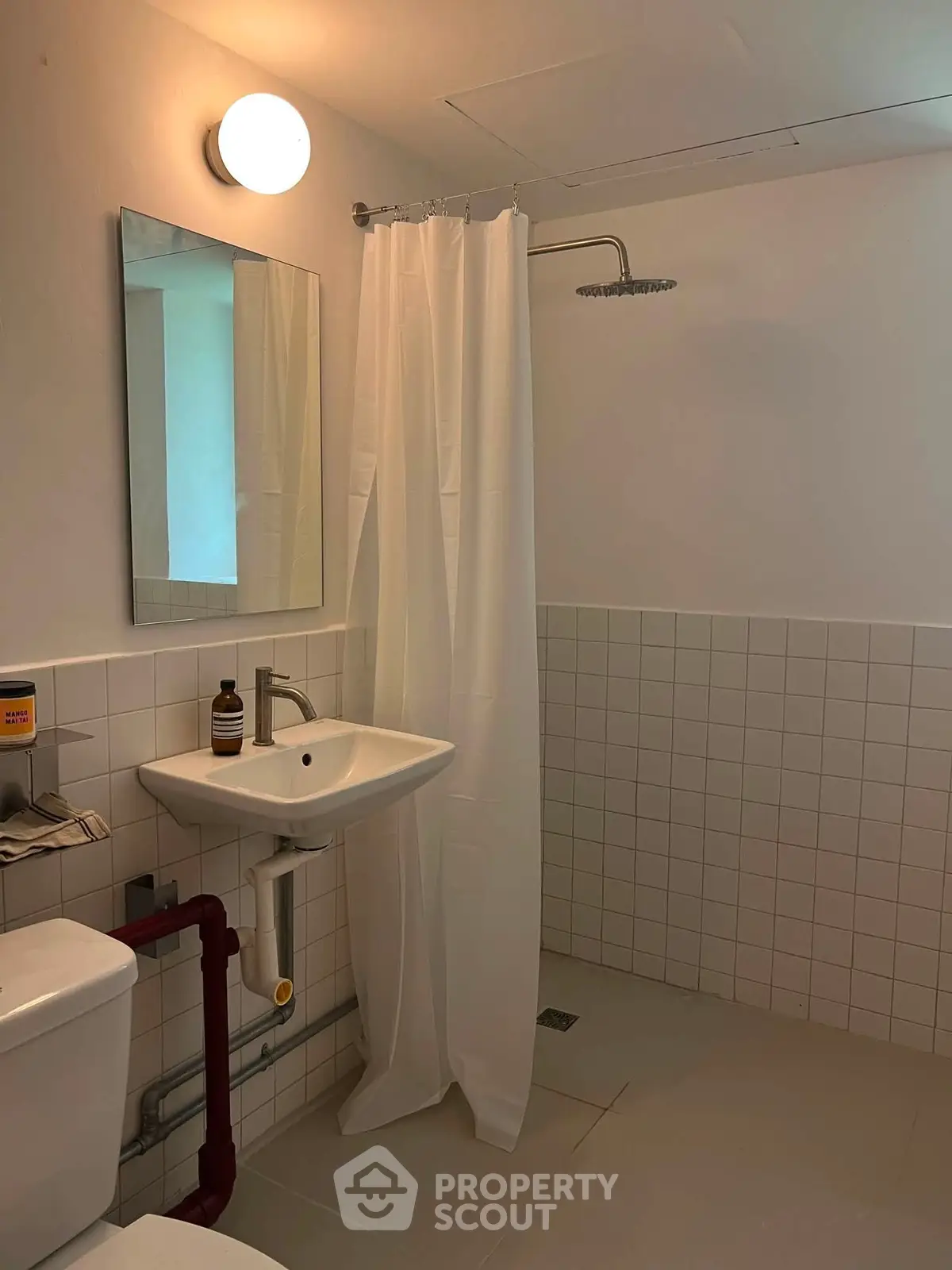 Modern bathroom with shower, sink, and toilet in minimalist design.