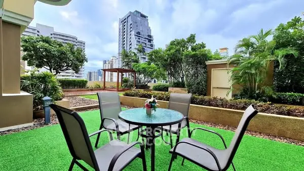 Elegant outdoor garden with modern seating and lush greenery in urban setting.