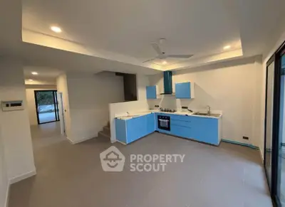 Modern open-layout kitchen with blue cabinets and sleek design