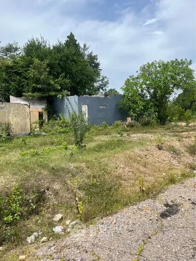 Explore potential with this rustic plot featuring partial structures and lush greenery, ideal for redevelopment.