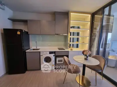 Modern kitchen with integrated appliances and stylish dining area in a contemporary apartment.