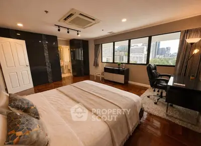 Spacious bedroom with city view, elegant decor, and modern furnishings in a high-rise apartment.