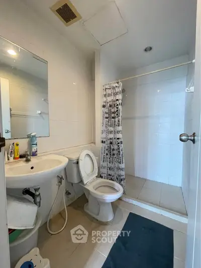 Modern bathroom with shower and toilet in a clean, minimalist design.