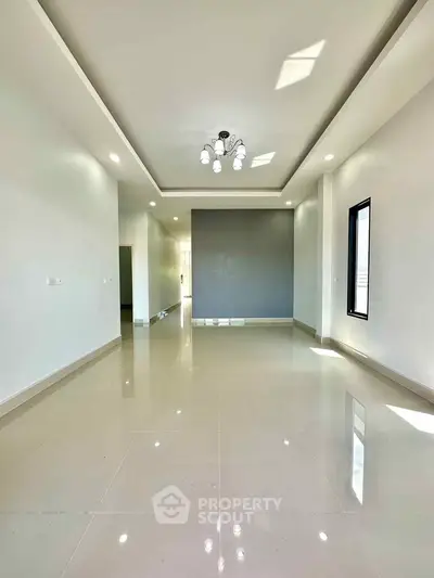 Spacious modern living room with elegant lighting and glossy tiled floors
