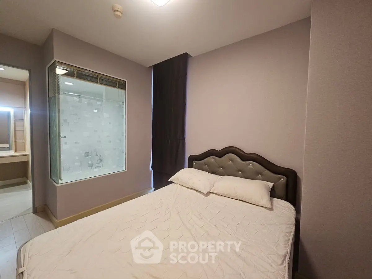 Modern bedroom with elegant bed and glass partition in stylish apartment