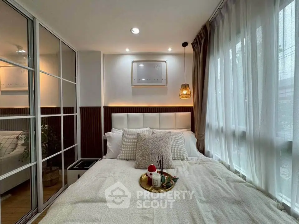 Cozy bedroom with large windows and elegant decor, perfect for relaxation.