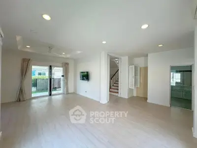 Spacious modern living room with large windows and garden view, perfect for family gatherings.