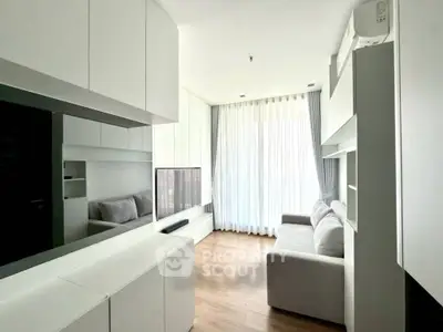 Modern living room with sleek white cabinetry and cozy gray sofa