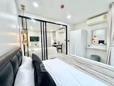 Modern bedroom with sliding glass doors and stylish decor in a contemporary apartment.