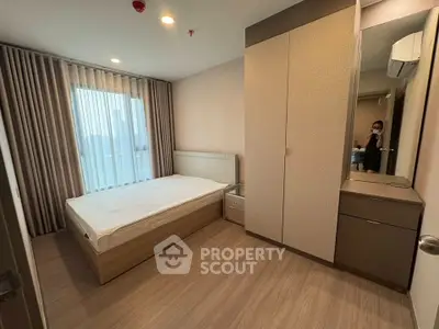 Modern bedroom with large window and stylish furniture in a contemporary apartment.