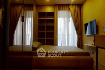 Luxurious bedroom with modern design, featuring a wall-mounted TV and elegant curtains.