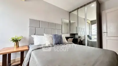 Modern bedroom with stylish decor and mirrored wardrobe in a cozy apartment.