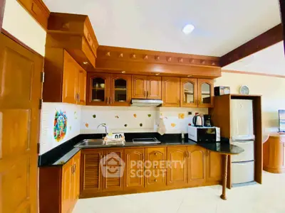 Spacious kitchen with wooden cabinets and modern appliances