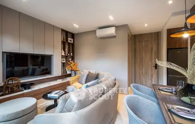 Modern living room with stylish decor and open layout, featuring cozy seating and elegant lighting.