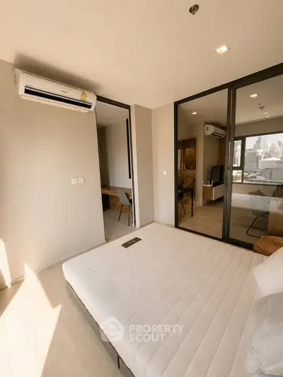 Modern bedroom with large windows and city view, featuring minimalist decor and air conditioning.
