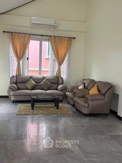 Spacious living room with elegant sofas and large window for natural light.