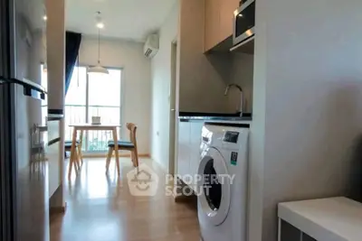 Modern apartment with open kitchen and dining area, featuring a washing machine and stylish decor.