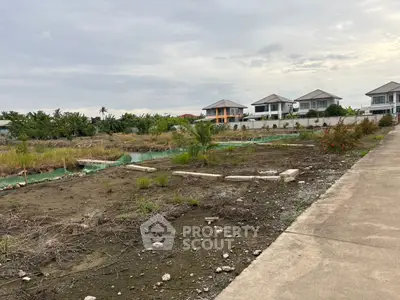 Vacant land plot with potential for development in a residential area with nearby houses.