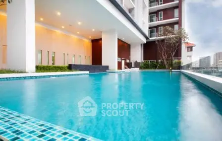 Luxurious residential building with a pristine swimming pool and modern architecture.
