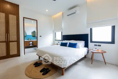 Modern bedroom with ensuite bathroom, featuring stylish decor and natural light.