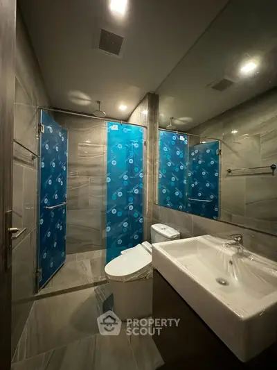 Modern bathroom with sleek fixtures and glass shower enclosure