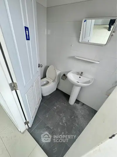 Compact bathroom with modern fixtures and tiled flooring, ideal for small spaces.