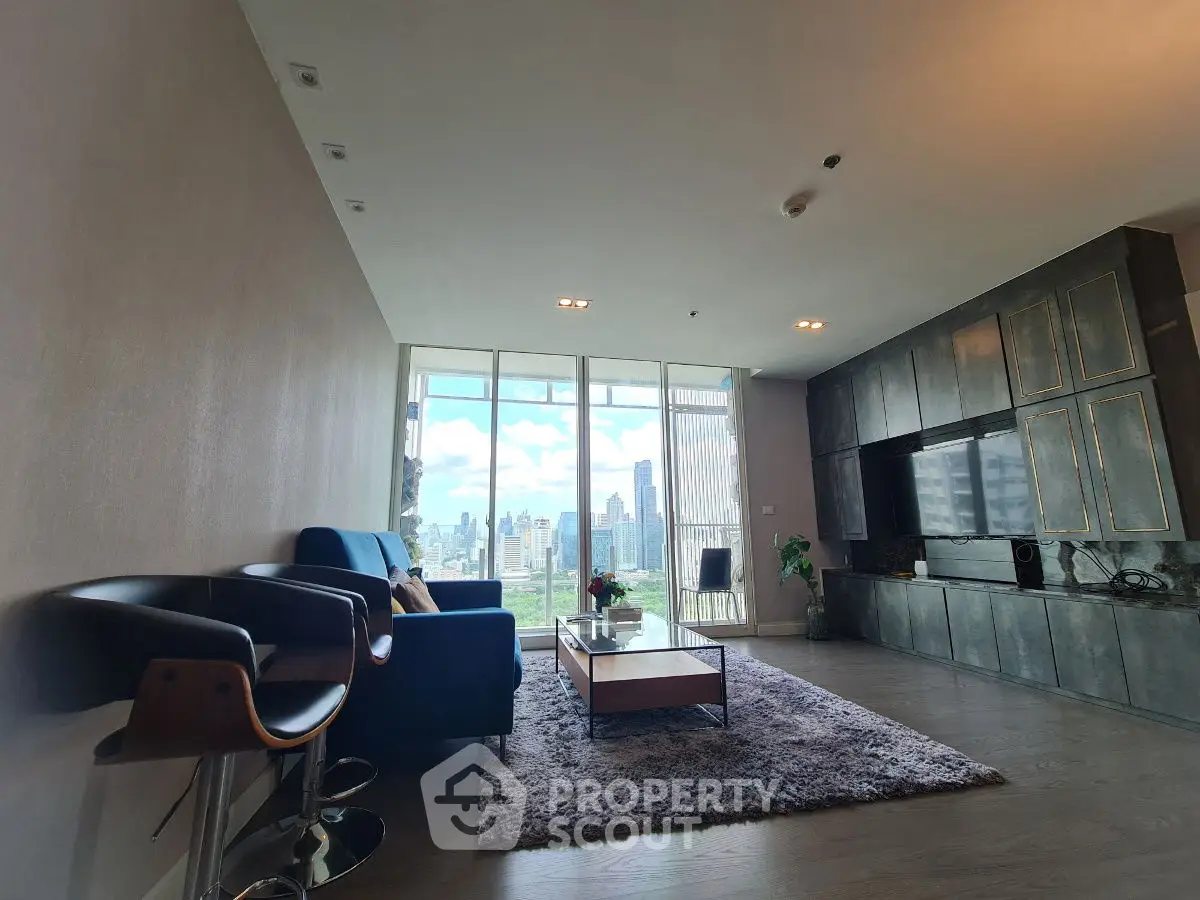 Spacious living room with modern decor and stunning city view through large windows.