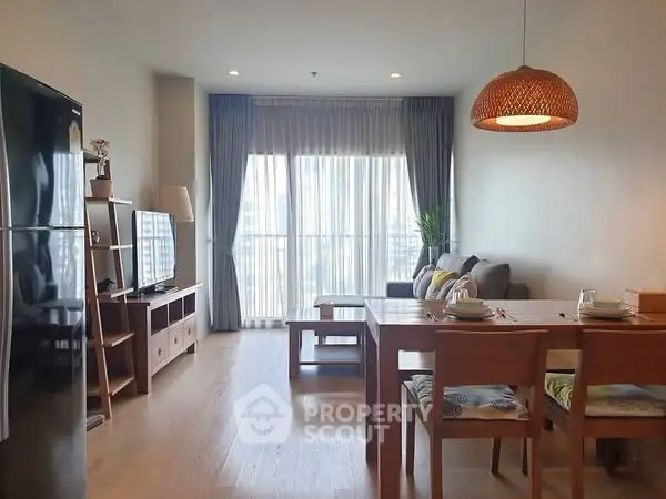 Modern living room with dining area, large window, and stylish decor