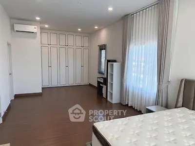 Spacious bedroom with elegant curtains and ample storage space