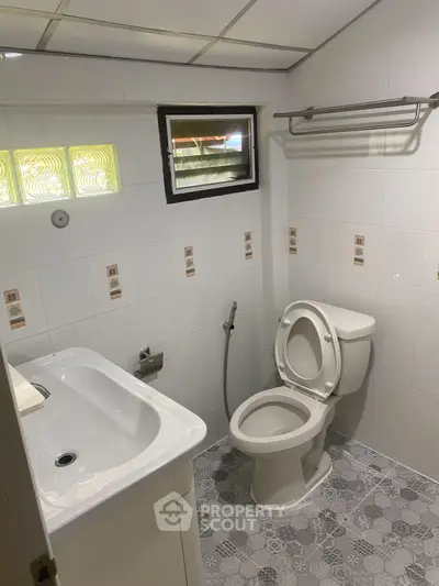 Compact bathroom with modern fixtures and tiled flooring