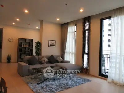 Spacious modern living room with large windows and stylish decor in a luxury apartment.