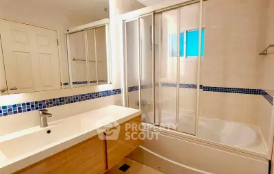 Modern bathroom with sleek design, featuring a bathtub and spacious vanity.