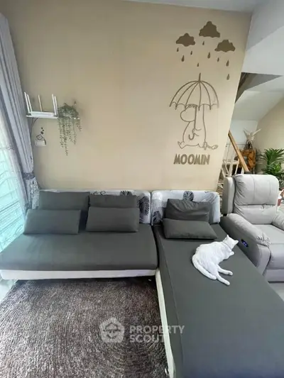 Cozy living room with stylish gray sofa and charming wall art, perfect for relaxation.