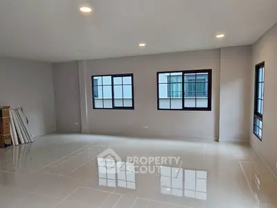 Spacious unfurnished room with glossy tiled floors and large windows in modern apartment.