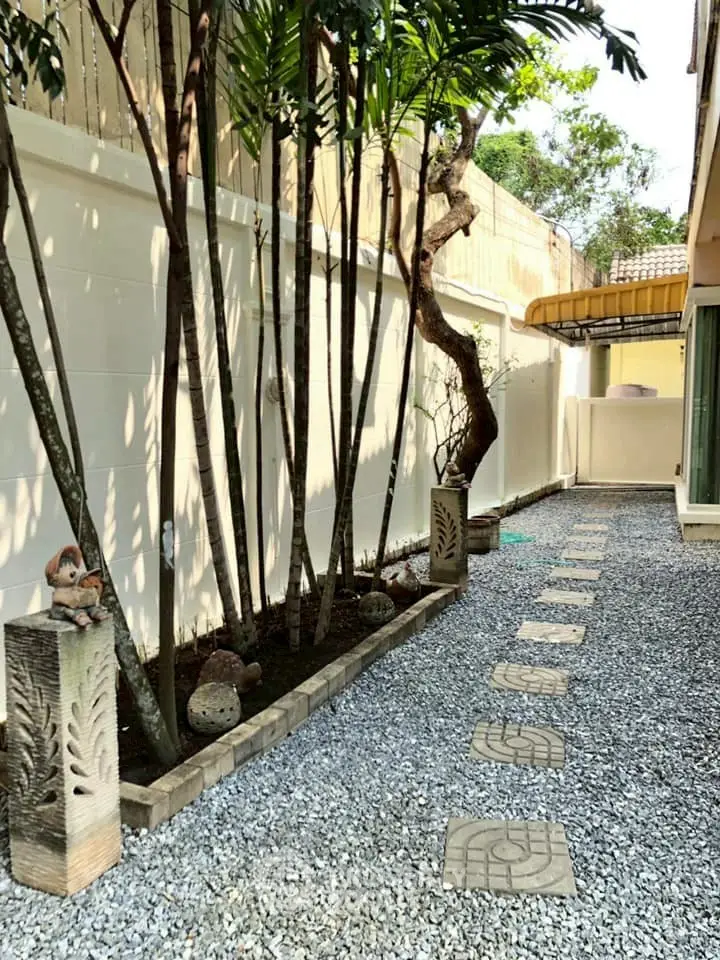 Charming garden pathway with decorative stone elements and lush greenery, perfect for serene outdoor living.
