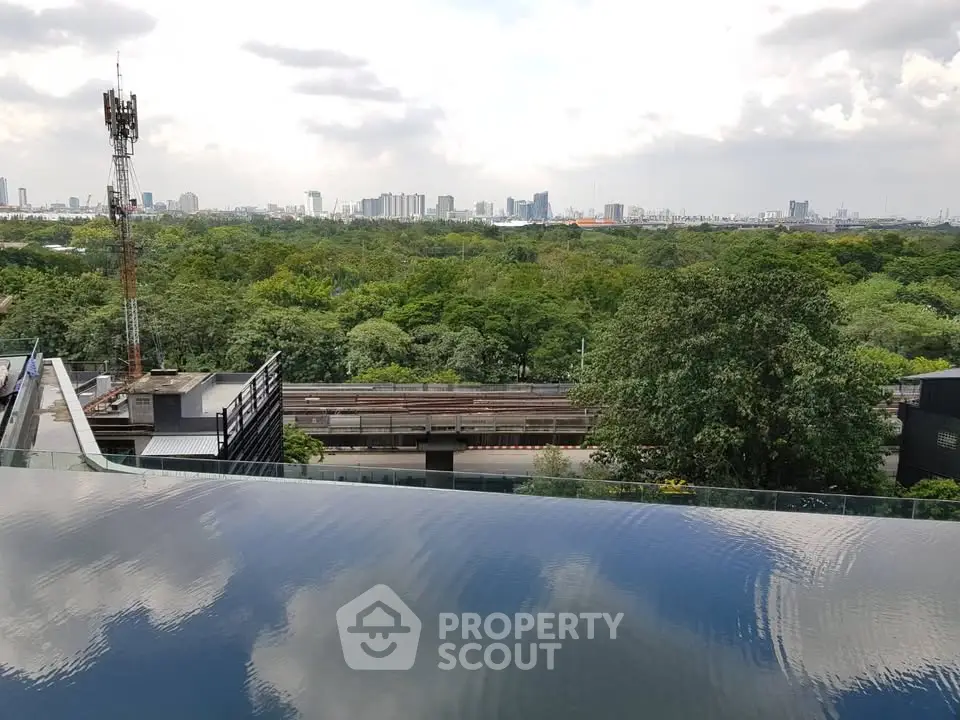 Stunning cityscape view from a rooftop infinity pool overlooking lush greenery and skyline.