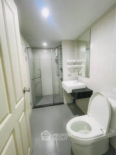 Modern bathroom with glass shower and sleek fixtures in a contemporary home.