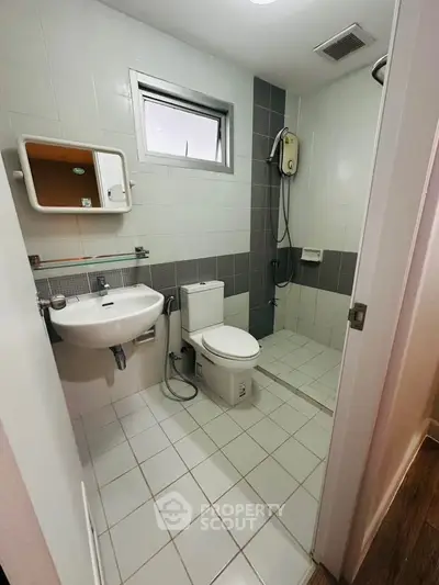 Modern bathroom with sleek design, featuring a shower, toilet, and sink in a compact layout.