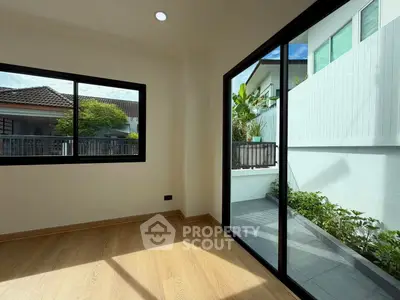 Bright room with large windows and garden view, perfect for a cozy living space.