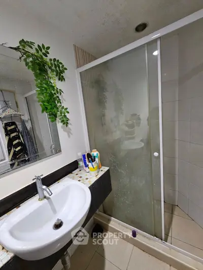 Modern bathroom with glass shower and stylish sink in a contemporary home.