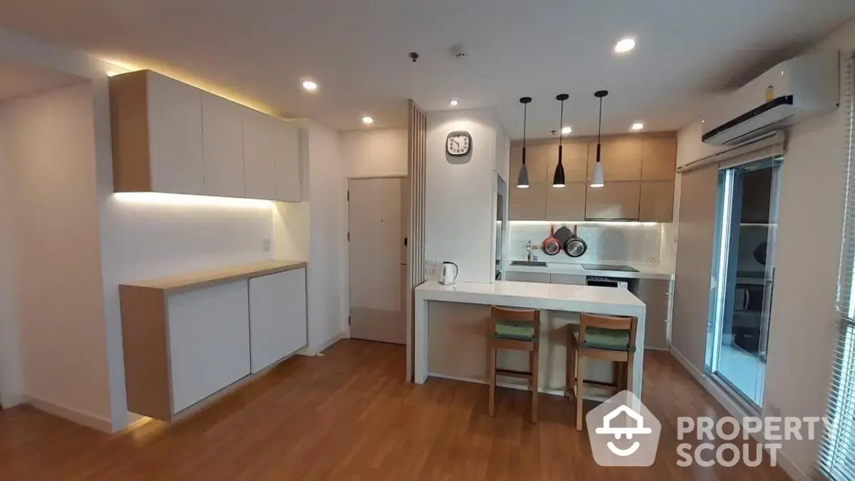 Modern kitchen with sleek cabinetry and breakfast bar in open layout