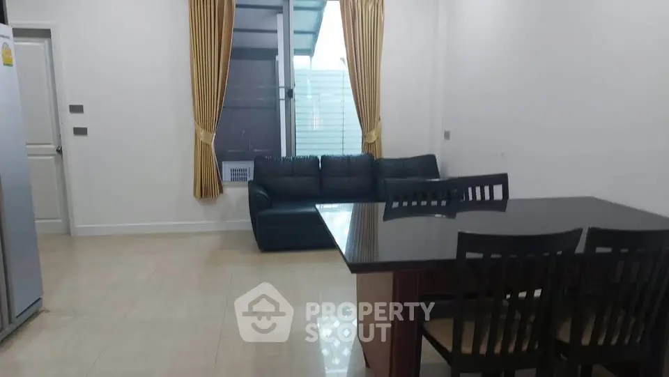 Spacious living room with modern furniture and large window for natural light.
