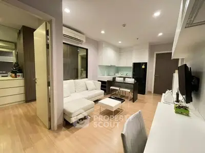 Modern open-layout living room with sleek kitchen and cozy seating area