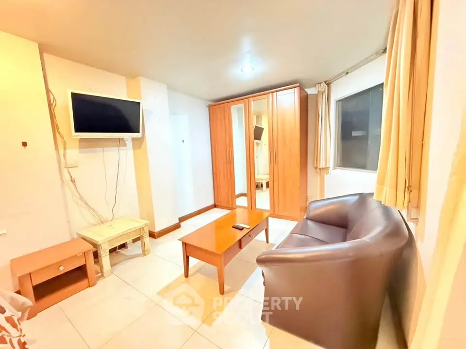 Cozy living room with modern furniture and wall-mounted TV in a bright apartment.