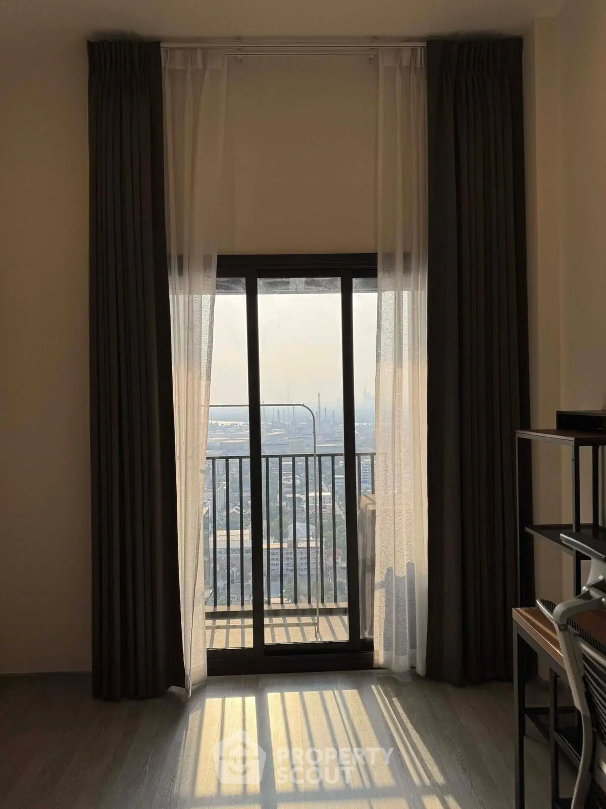 Stunning city view from a modern apartment balcony with elegant curtains.
