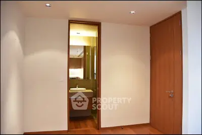 Modern bathroom entrance with wooden door and sleek design