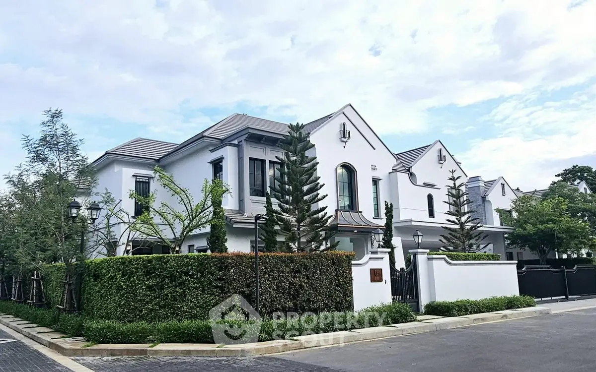 Elegant white villa with lush greenery and modern architecture in a serene neighborhood.